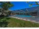 A screened-in pool area with a well-maintained lawn and landscaping at 3133 Pineview Dr, Holiday, FL 34691