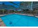 Bright and refreshing in-ground screened pool with a lounge chair at 3133 Pineview Dr, Holiday, FL 34691