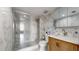 A bathroom with white marble walls, a glass shower, and a light wood vanity with a white countertop at 400 Island Way # 210, Clearwater Beach, FL 33767