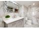 The bathroom features white marble walls, grey cabinets, a white countertop, and a unique mirror at 400 Island Way # 210, Clearwater Beach, FL 33767