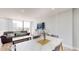 Stylish living room featuring a plush sofa, a dining table, and balcony access for outdoor enjoyment at 400 Island Way # 210, Clearwater Beach, FL 33767