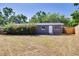 View of backyard of home showcasing a fenced in lawn and trees at 401 Patica Ne Rd, St Petersburg, FL 33702
