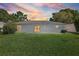 Spacious backyard with lush green grass, patio, and sliding glass door at 4148 102Nd N Pl, Clearwater, FL 33762