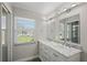 Bright bathroom with double sink vanity, marble countertop, and well lit mirror at 4148 102Nd N Pl, Clearwater, FL 33762