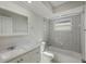 Bright bathroom featuring a shower-tub combo with white subway tile and a white vanity with gray countertop at 4148 102Nd N Pl, Clearwater, FL 33762