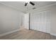 Bedroom with gray walls, white trim, wood-look tile, ceiling fan, and closet space at 4148 102Nd N Pl, Clearwater, FL 33762