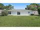 Exterior of the house as seen from the backyard with grassy area at 4148 102Nd N Pl, Clearwater, FL 33762