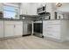 Bright kitchen boasts stainless steel appliances, granite countertops, white cabinets, and wood look tile flooring at 4148 102Nd N Pl, Clearwater, FL 33762