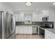Stylish kitchen featuring white cabinetry, granite countertops, stainless steel appliances, and decorative backsplash at 4148 102Nd N Pl, Clearwater, FL 33762