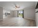 Open-concept living room showcasing wood-look tile flooring, neutral walls, and a view into the modern kitchen at 4148 102Nd N Pl, Clearwater, FL 33762