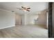 Bright living room with wood-look tile flooring and a view of the kitchen through an open doorway at 4148 102Nd N Pl, Clearwater, FL 33762