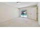 Bright bedroom with neutral carpet, white walls, and sliding glass doors to the screened pool area at 4226 Saltwater Blvd, Tampa, FL 33615