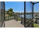 A grey wooden deck overlooks a canal, offering a peaceful view of boats and waterfront homes at 4226 Saltwater Blvd, Tampa, FL 33615