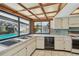 Sunlit kitchen features white cabinets, patterned tile floors, and a view of the screened-in pool at 4226 Saltwater Blvd, Tampa, FL 33615