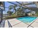 Relaxing screened-in pool area with palm trees, a boat dock, and water views at 4226 Saltwater Blvd, Tampa, FL 33615