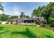 Expansive backyard showcasing lush green lawn, mature trees, a sparkling pool, and outdoor seating at 500 Tallahassee Ne Dr, St Petersburg, FL 33702