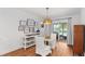 Bright dining area with view to the pool, a modern light fixture, and hardwood floors at 500 Tallahassee Ne Dr, St Petersburg, FL 33702
