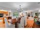 Open-concept dining room flows to living area, featuring wood floors and modern lighting, with views of the outdoor pool at 500 Tallahassee Ne Dr, St Petersburg, FL 33702