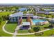 Aerial view of the community clubhouse, pool, and surrounding lush landscape with a lakeside view at 5609 Silver Sun Dr, Apollo Beach, FL 33572