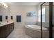A bathroom with a corner tub, shower with a black frame, double sink, and tiled floors at 5609 Silver Sun Dr, Apollo Beach, FL 33572