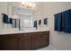 Bathroom featuring a double vanity with a white countertop, dark wood cabinets, and large mirror at 5609 Silver Sun Dr, Apollo Beach, FL 33572