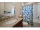 Updated bathroom features granite counters, a sailboat-themed shower curtain, and a large mirror at 5609 Silver Sun Dr, Apollo Beach, FL 33572