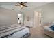A neutral bedroom with a ceiling fan, white dresser, and a doorway to another room at 5609 Silver Sun Dr, Apollo Beach, FL 33572