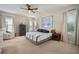 Well-lit bedroom with a neutral color scheme, ceiling fan, and large windows at 5609 Silver Sun Dr, Apollo Beach, FL 33572