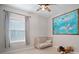 A bedroom featuring a small crib, ocean themed decorations, and large window at 5609 Silver Sun Dr, Apollo Beach, FL 33572