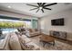 Bright living room featuring stylish furnishings, a ceiling fan, and access to outdoor pool at 5609 Silver Sun Dr, Apollo Beach, FL 33572