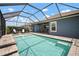 Enjoy a screened-in pool with brick surround, patio seating, and an adjacent covered outdoor dining area at 5609 Silver Sun Dr, Apollo Beach, FL 33572