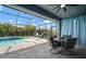 Screened-in pool area features a waterfall feature, brick patio, and comfortable outdoor seating under a covered lanai at 5609 Silver Sun Dr, Apollo Beach, FL 33572
