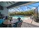 This covered patio offers views of a screened pool with a waterfall feature and a well-manicured backyard at 5609 Silver Sun Dr, Apollo Beach, FL 33572