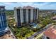 Aerial view featuring a building, pool, surrounded by greenery and city skyline at 5823 Bowen Daniel Dr # 606, Tampa, FL 33616