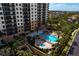 Aerial view of the community pool and a hot tub with lush landscaping surrounding the area at 5823 Bowen Daniel Dr # 606, Tampa, FL 33616