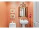 Stylish powder room with unique mirror and pedestal sink at 5823 Bowen Daniel Dr # 606, Tampa, FL 33616