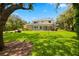 Spacious backyard featuring a screened lanai, lush lawn, and mature trees for privacy at 5902 Audubon Manor Blvd, Lithia, FL 33547