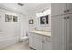 Bright bathroom featuring a shower-tub combo, white cabinetry, and a framed mirror at 5902 Audubon Manor Blvd, Lithia, FL 33547