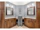 Bathroom featuring dual vanities, wood cabinetry, granite countertops, and framed mirrors at 5902 Audubon Manor Blvd, Lithia, FL 33547