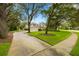 Charming yellow home with well-maintained lawn, mature trees, and a curving driveway leading to a three-car garage at 5902 Audubon Manor Blvd, Lithia, FL 33547