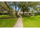 Inviting two-story home with lush green lawn, mature trees, and a charming front exterior at 5902 Audubon Manor Blvd, Lithia, FL 33547
