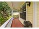 Cozy front porch with brick flooring, white railings, and ample space for seating, adjacent to the main house at 5902 Audubon Manor Blvd, Lithia, FL 33547