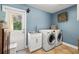 Well-equipped laundry room with blue walls, a stainless steel sink, modern washer, and dryer set at 5902 Audubon Manor Blvd, Lithia, FL 33547
