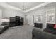 Spacious living room with a modern chandelier, stylish furniture, and gray carpeting at 5902 Audubon Manor Blvd, Lithia, FL 33547