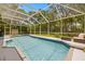 Inviting screened-in pool area with clear water, lounge chairs, and a serene backyard setting, perfect for relaxation at 5902 Audubon Manor Blvd, Lithia, FL 33547