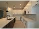 Kitchen features white and dark cabinets, center island with sink and pendant lights, and stainless appliances at 6270 Broad Field Ave, Apollo Beach, FL 33572