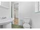 Clean bathroom with a pedestal sink, toilet, and open doorway at 628 Bosphorous Ave, Tampa, FL 33606
