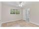 Bright bedroom with tile flooring, white walls and trim, ceiling fan, and window with backyard views at 628 Bosphorous Ave, Tampa, FL 33606