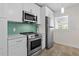 Updated kitchen featuring stainless steel appliances, sleek white cabinetry, and turquoise backsplash at 628 Bosphorous Ave, Tampa, FL 33606