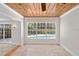 Bright living room featuring tile floors, wood plank ceiling with ceiling fan, and a large window overlooking the pool at 628 Bosphorous Ave, Tampa, FL 33606
